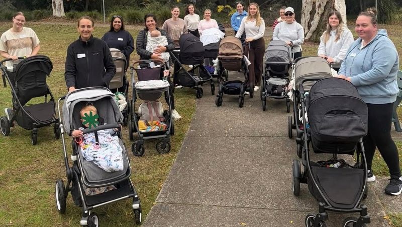 A group of mothers standing with their prams on a park path
